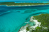 Luftaufnahme mit Blick auf den Schatten des Flugzeugs, einen Jetski und klares tropisches Wasser und Inseln in der Exuma-Inselkette auf den Bahamas in der Nähe von Staniel Cay.
