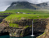 Wasserfall in der Nähe von Gasadalur, einem der Wahrzeichen der Färöer Inseln. Insel Vagar, Teil der Färöer Inseln im Nordatlantik. Dänemark
