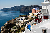 Oia, Santorini, Greece. Village of Oia with blue and red wooden gates and painted buildings overlook the Caldera