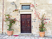 Italien, Basilikata, Matera. Blumen schmücken den Eingang eines Sassi-Hauses.