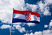Die kroatische Flagge vor blauem Himmel und Wolken, Ston, Kroatien