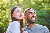 Smiling young couple sitting in public park