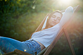 Young woman sleeping on chair in park