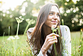 Portrait of smiling young woman lying in park