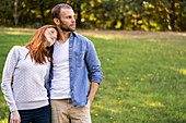 Lächelndes junges Paar, das einen Spaziergang im Park genießt