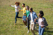 Fröhliche junge Freunde haben Spaß beim gemeinsamen Laufen im Park