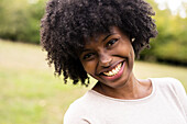 Close-up of smiling young woman standing in park