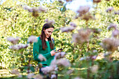 Smiling young woman text messaging on smartphone