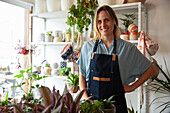 Adult plant store worker wearing apron while looking at the camera