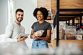 Male and female entrepreneur looking at the camera while standing in pastry store