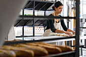 Weitwinkelaufnahme einer lateinamerikanischen Bäckereibesitzerin beim Kneten von Gebäckteig