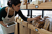 Aufnahme einer lateinamerikanischen Bäckereibesitzerin, die die Preise ihrer Waren überprüft