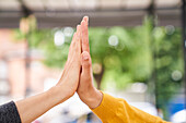 Close-up shot of women's hands high-fiving each other