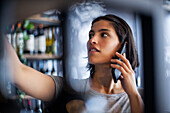 Angestellter in einer Weinhandlung telefoniert mit einem Smartphone