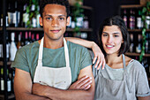 Wine store owner with arms crossed standing next to business partner