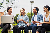 Gruppe von Mitarbeitern bei einer Besprechung im Freien sitzend