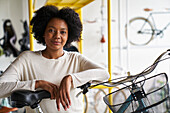 Portrait of African-American woman shop owner standing in her bicycle store
