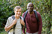 Zwei männliche Freunde, die im Wald wandern, halten an, um ein Foto zu machen
