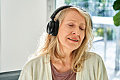 Ältere Frau hört gerne Musik über Kopfhörer