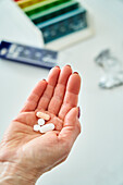 Senior woman's hand holding bunch of pills