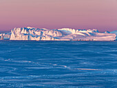 Sonnenaufgang im Winter am Ilulissat Fjord in der Diskobucht in Westgrönland. Der Fjord ist Teil des UNESCO-Weltkulturerbes. Grönland, Dänemark.