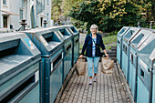 Frau trägt Papiersäcke mit Recyclingmaterial