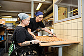 Behinderte Frau arbeitet in einer Lebensmittelfabrik