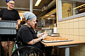 Behinderte Frau bei der Arbeit in einer Lebensmittelfabrik