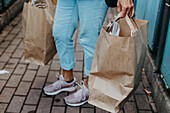 Low section of woman carrying paper bags