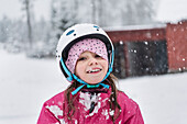 Porträt eines lächelnden Mädchens mit Helm im Winter