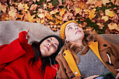 Freunde auf dem Boden liegend in Herbstlandschaft