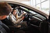 Customers trying car in car dealership office