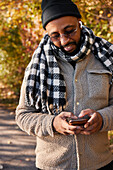 Mann telefoniert im Herbstpark