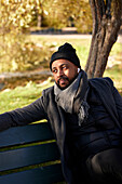 Man sitting on bench in autumn park