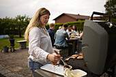 Woman preparing food on barbecue