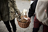 People carrying basket with wood