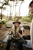 Smiling woman holding thermos