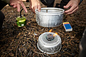 Person putting pot on camping stove