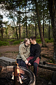 Couple sitting near campfire