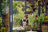 Woman sitting in greenhouse