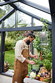 Mann bei der Gartenarbeit im Gewächshaus