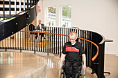 Behinderter Mann im Rollstuhl im Korridor