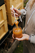 B-Imker hält Glas mit Honig