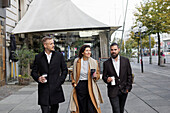 Smiling colleagues walking in street