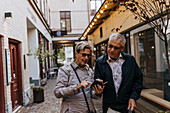 Senior couple using smart phone in city