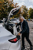 Man putting shopping bags in car trunk