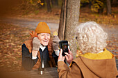 Ältere Frau fotografiert ihren Partner im Park