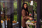 Smiling woman standing in greenhouse