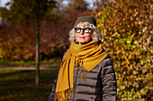 Porträt einer älteren Frau in einer Herbstlandschaft