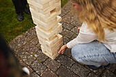 Frau spielt Riesen-Jenga